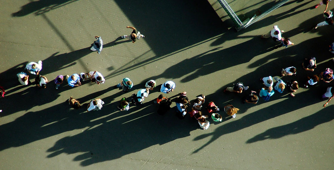 Imagen aérea de una fila de personas hacen cola esperando algo